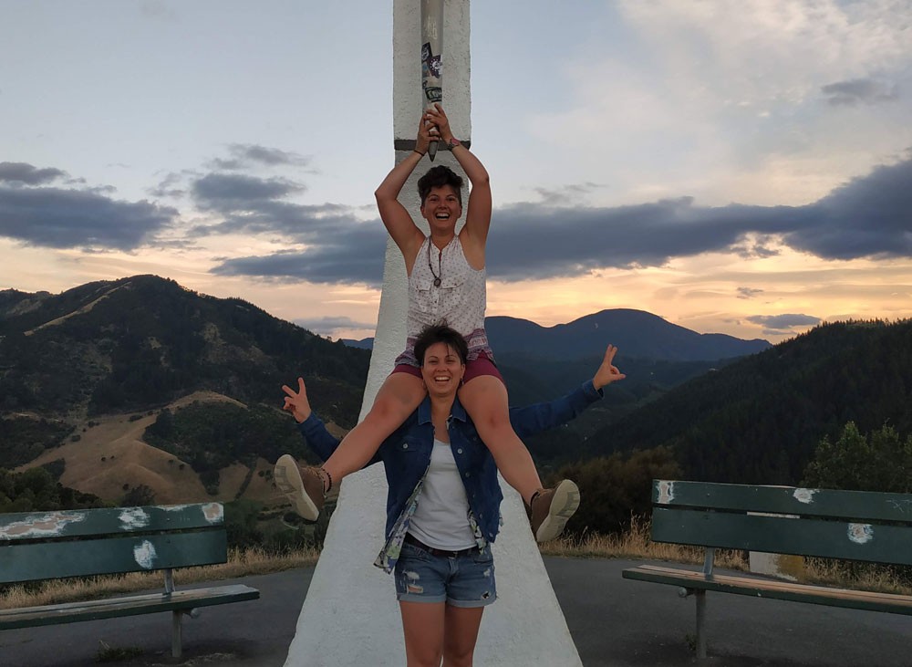 dos chicas posando para cámara delante de un monumento